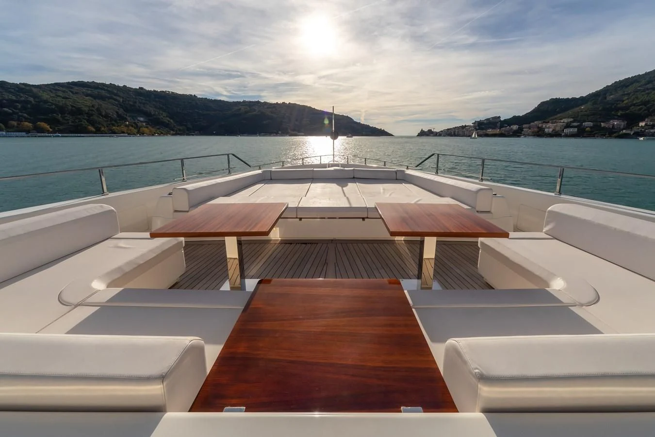 a deck with a view of the ocean and mountains in the background aboard FRANGELO Yacht for Sale