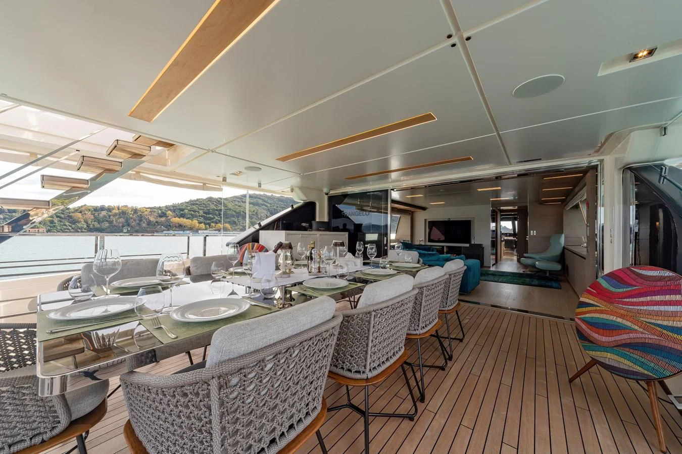 a room with a table chairs and a large umbrella aboard FRANGELO Yacht for Sale