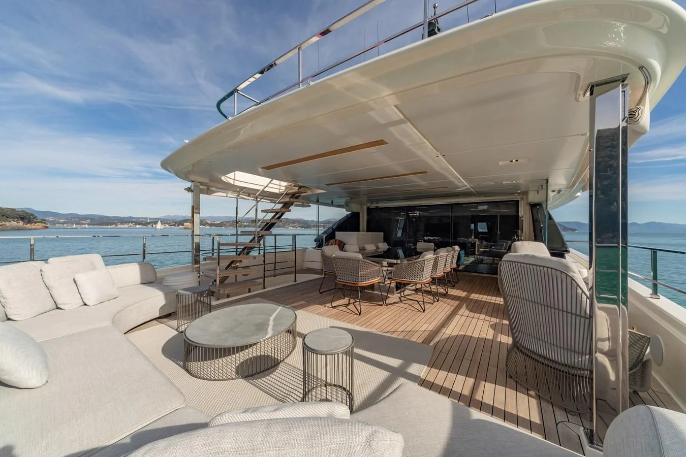 a deck with chairs and tables on it by the water aboard FRANGELO Yacht for Sale