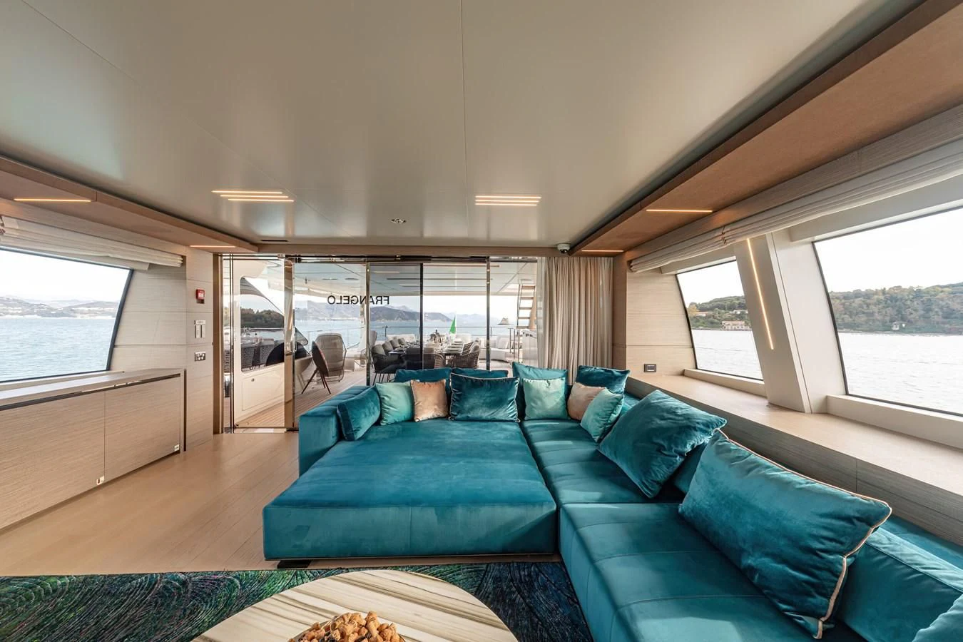 a large living room with a large blue couch aboard FRANGELO Yacht for Sale