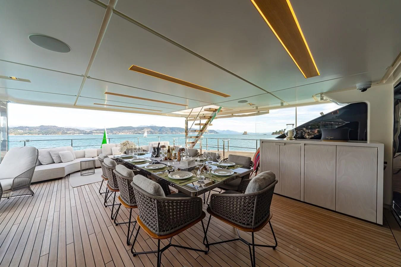 a dining table and chairs on a deck aboard FRANGELO Yacht for Sale