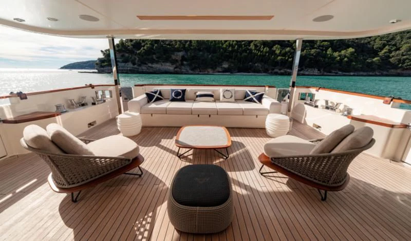 a lounge area on a deck overlooking a body of water aboard FRANGELO Yacht for Sale