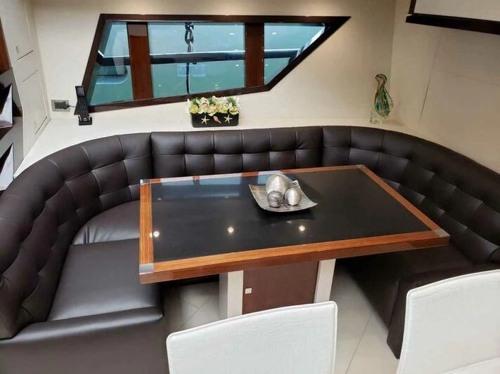 a black couch with a coffee table aboard CHAPTER II Yacht for Sale