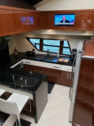 a kitchen with a tv and a large window aboard CHAPTER II Yacht for Sale