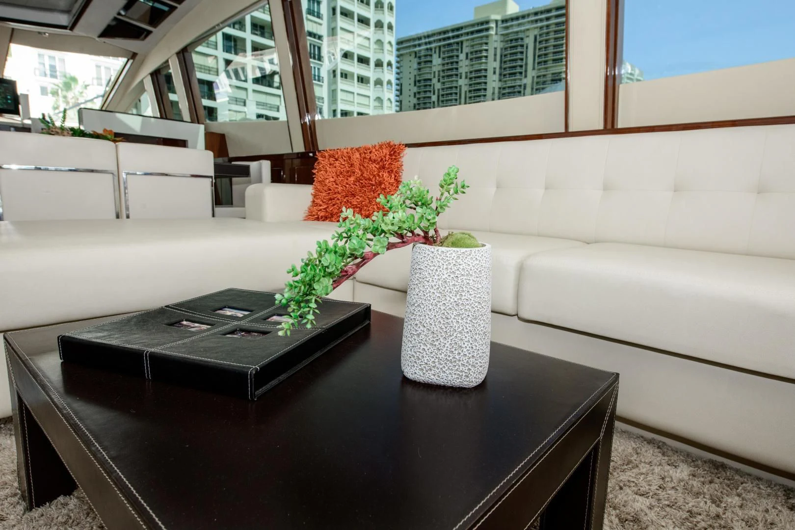 a black coffee table with a white couch and a black coffee table with a plant on it aboard CHAPTER II Yacht for Sale