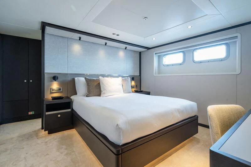 a bedroom with a bed and a desk aboard EMERALD Yacht for Charter