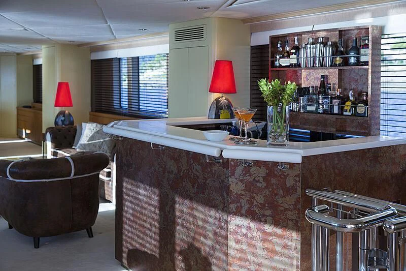 a living room with a bar and a table aboard EMERALD Yacht for Charter
