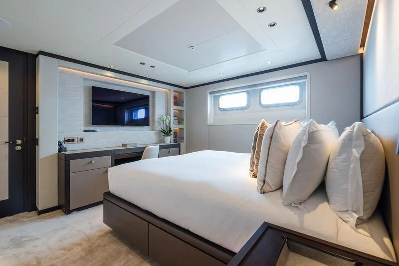 a bedroom with a bed and a television aboard EMERALD Yacht for Charter