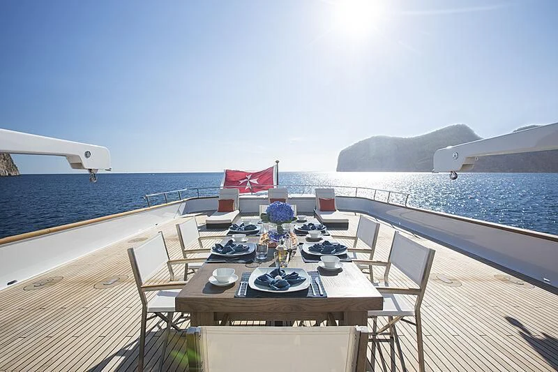 a table on a deck overlooking the ocean aboard EMERALD Yacht for Charter