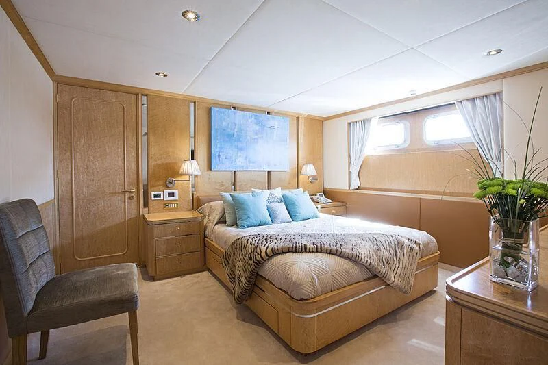 a bedroom with a bed and a chair aboard EMERALD Yacht for Charter