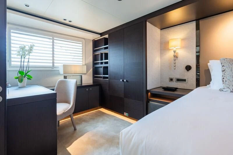 a bedroom with a bed and desk aboard EMERALD Yacht for Charter