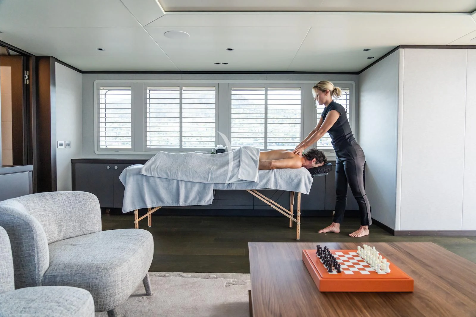 a man and a woman in a room with a table and a couch aboard EMERALD Yacht for Charter