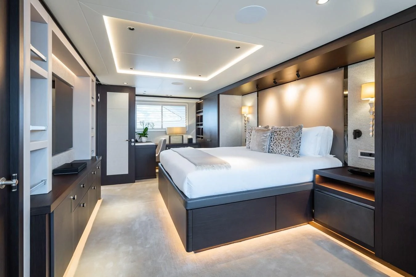 a room with a bed and desk aboard EMERALD Yacht for Charter