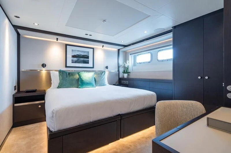 a bedroom with a bed and a desk aboard EMERALD Yacht for Charter