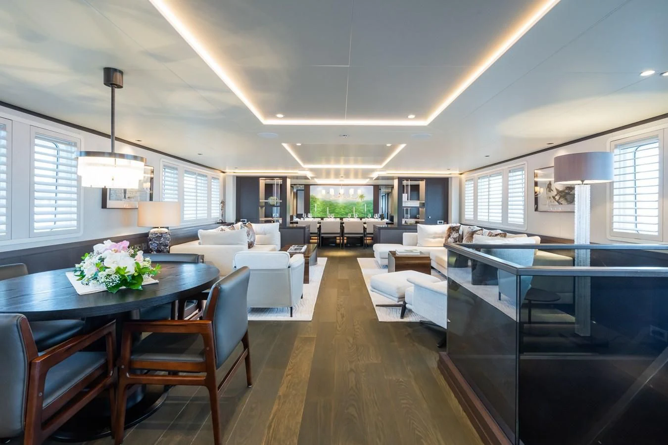 a living room with a dining table and a large window aboard EMERALD Yacht for Charter