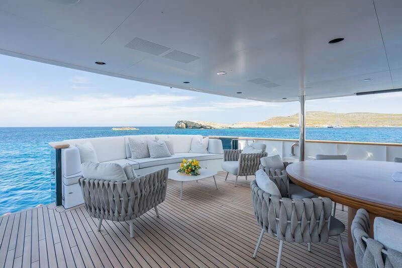 a deck with chairs and a table on it aboard EMERALD Yacht for Charter