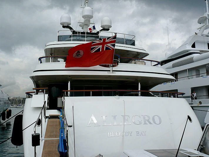 a large white boat with a red stripe on it aboard JAGUAR Yacht for Charter
