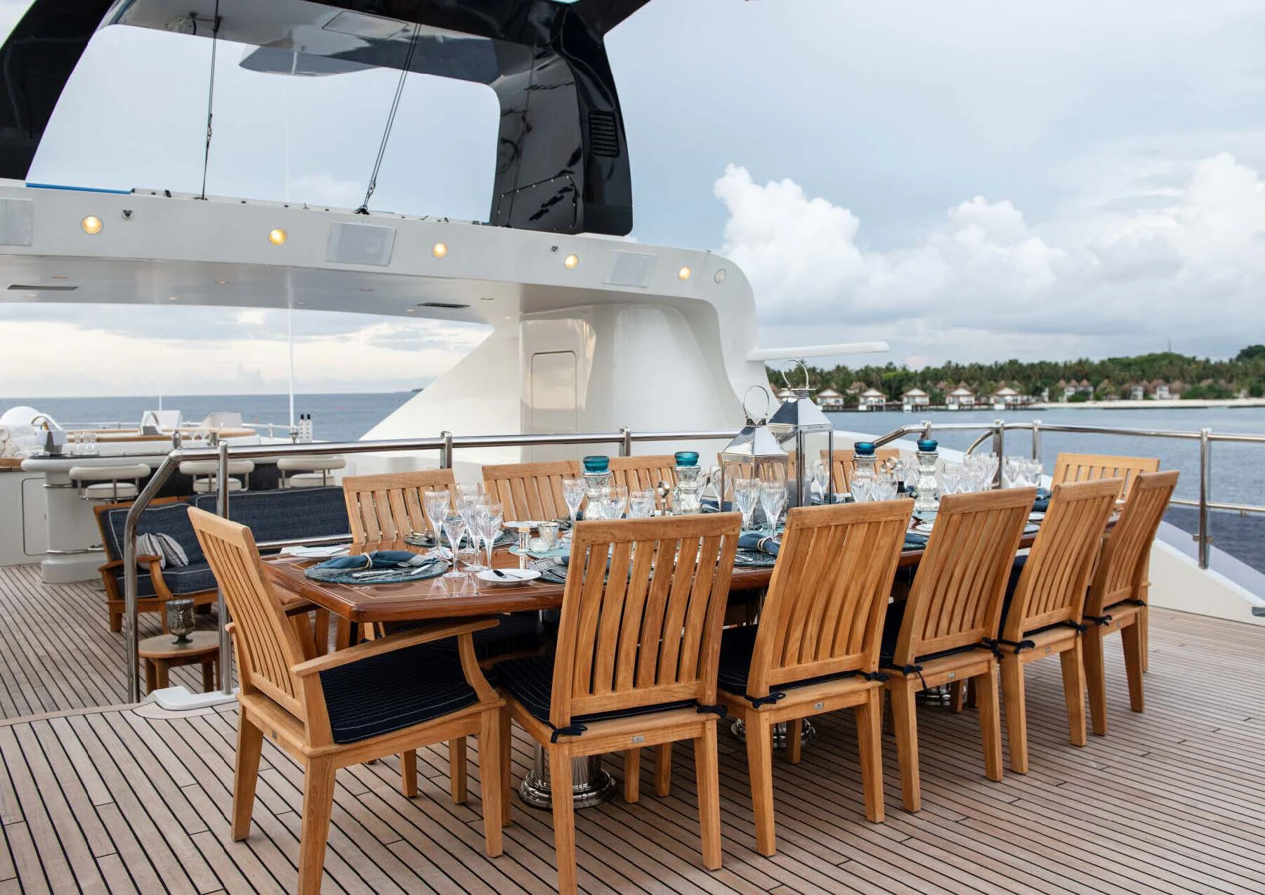 a table set for a meal on a deck overlooking a large body of water aboard JAGUAR Yacht for Charter