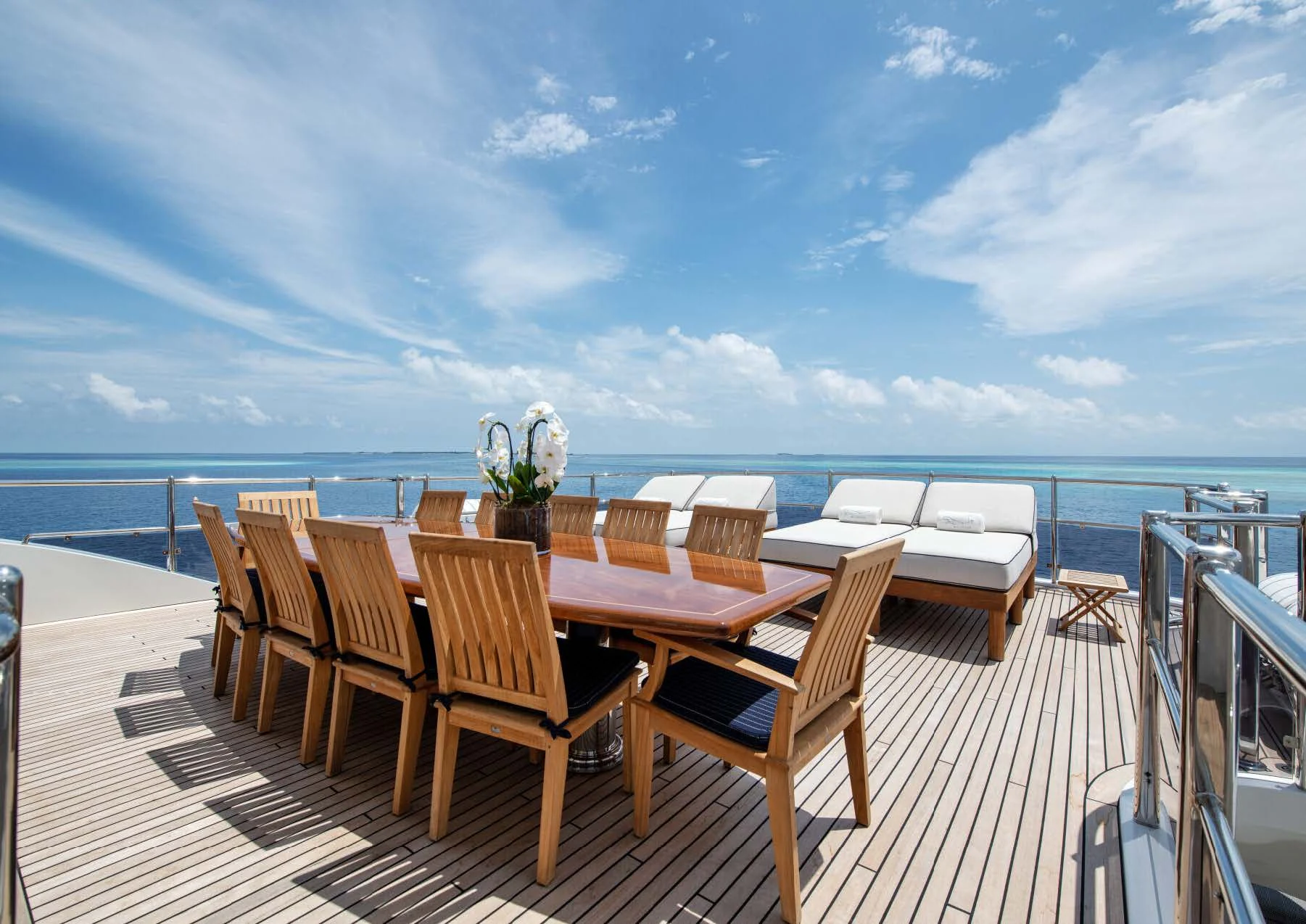 a deck with tables and chairs on it by the water aboard JAGUAR Yacht for Charter