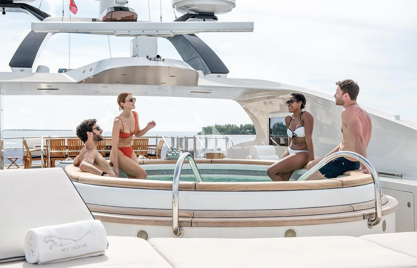 a group of people sitting on a boat aboard JAGUAR Yacht for Charter