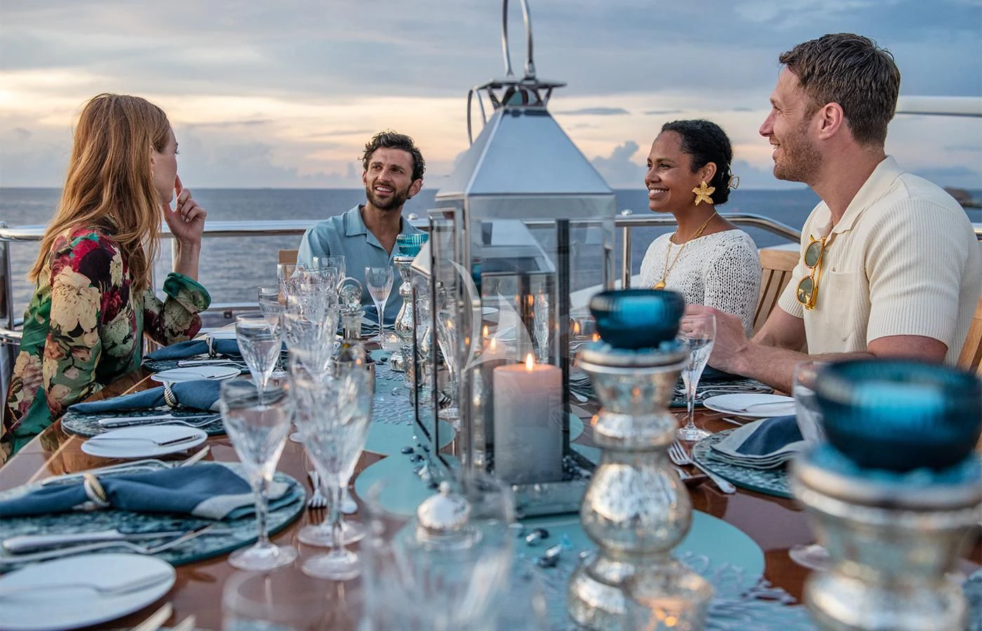 a group of people sitting at a table with wine glasses and plates aboard JAGUAR Yacht for Charter