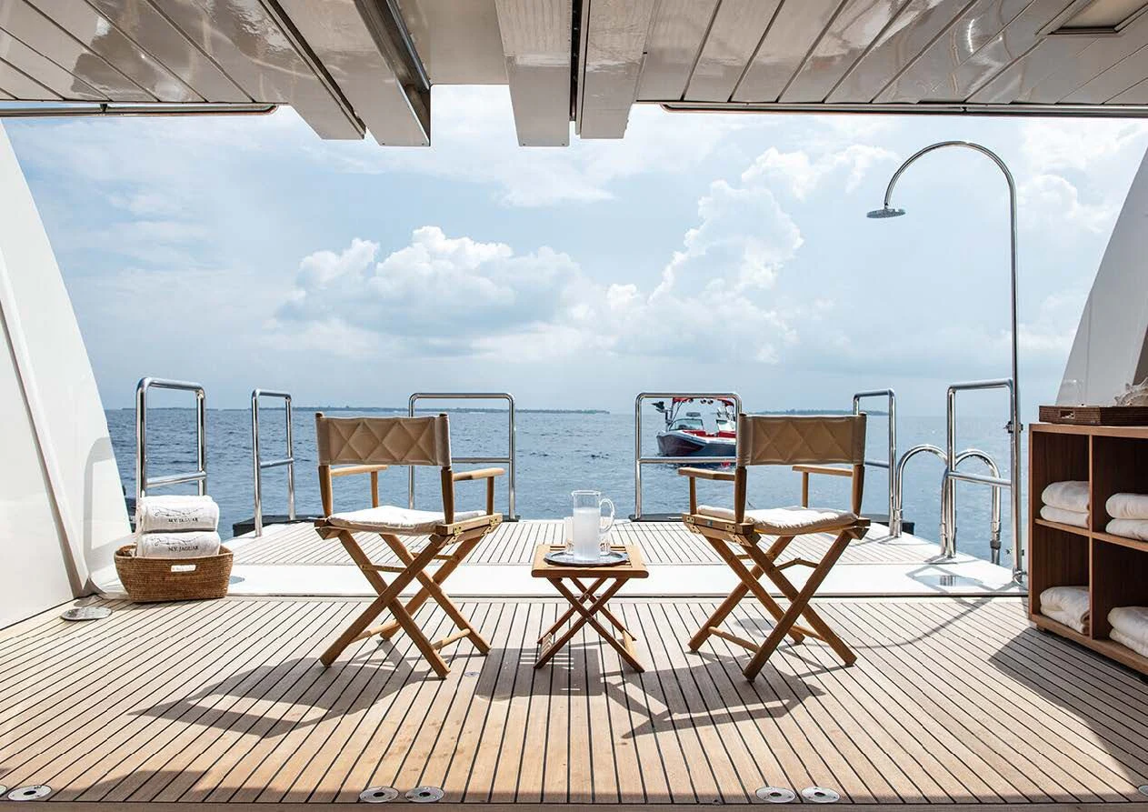 a deck with a table and chairs on it aboard JAGUAR Yacht for Charter