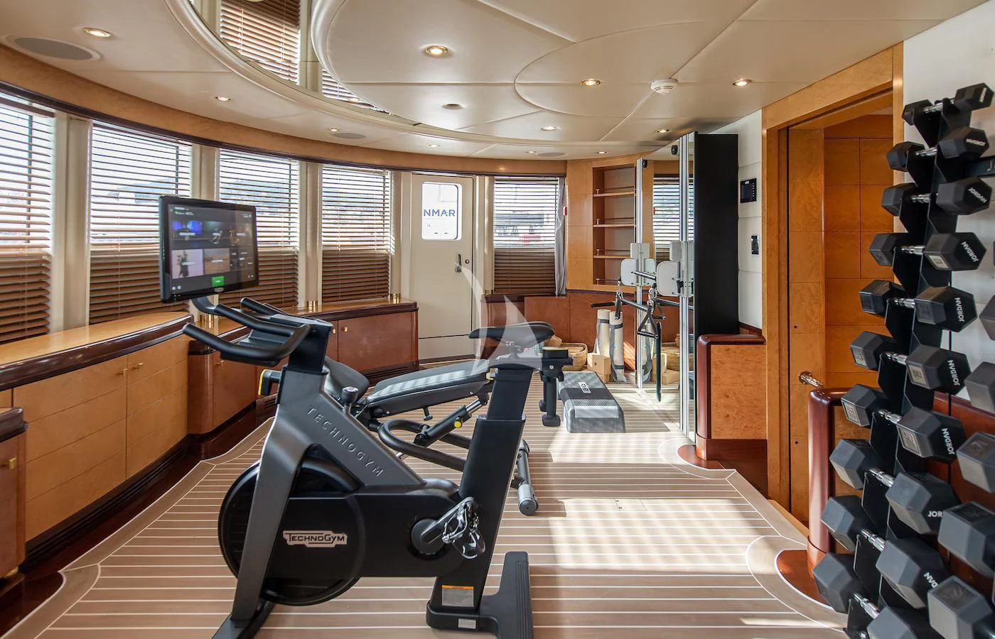 a room with a large mirror and a large gym with a large window aboard JAGUAR Yacht for Charter