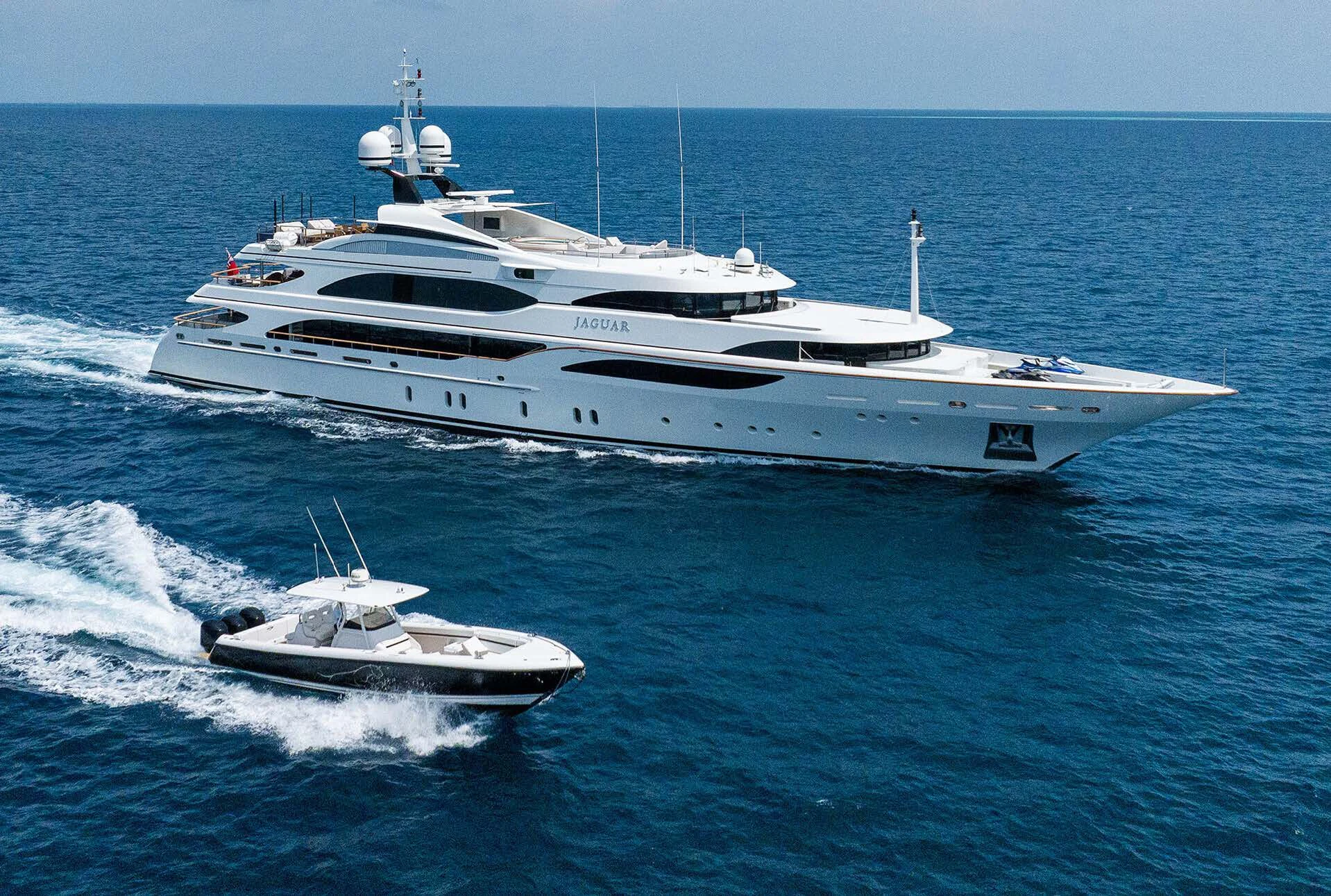 a large white yacht with a smaller boat on it aboard JAGUAR Yacht for Charter