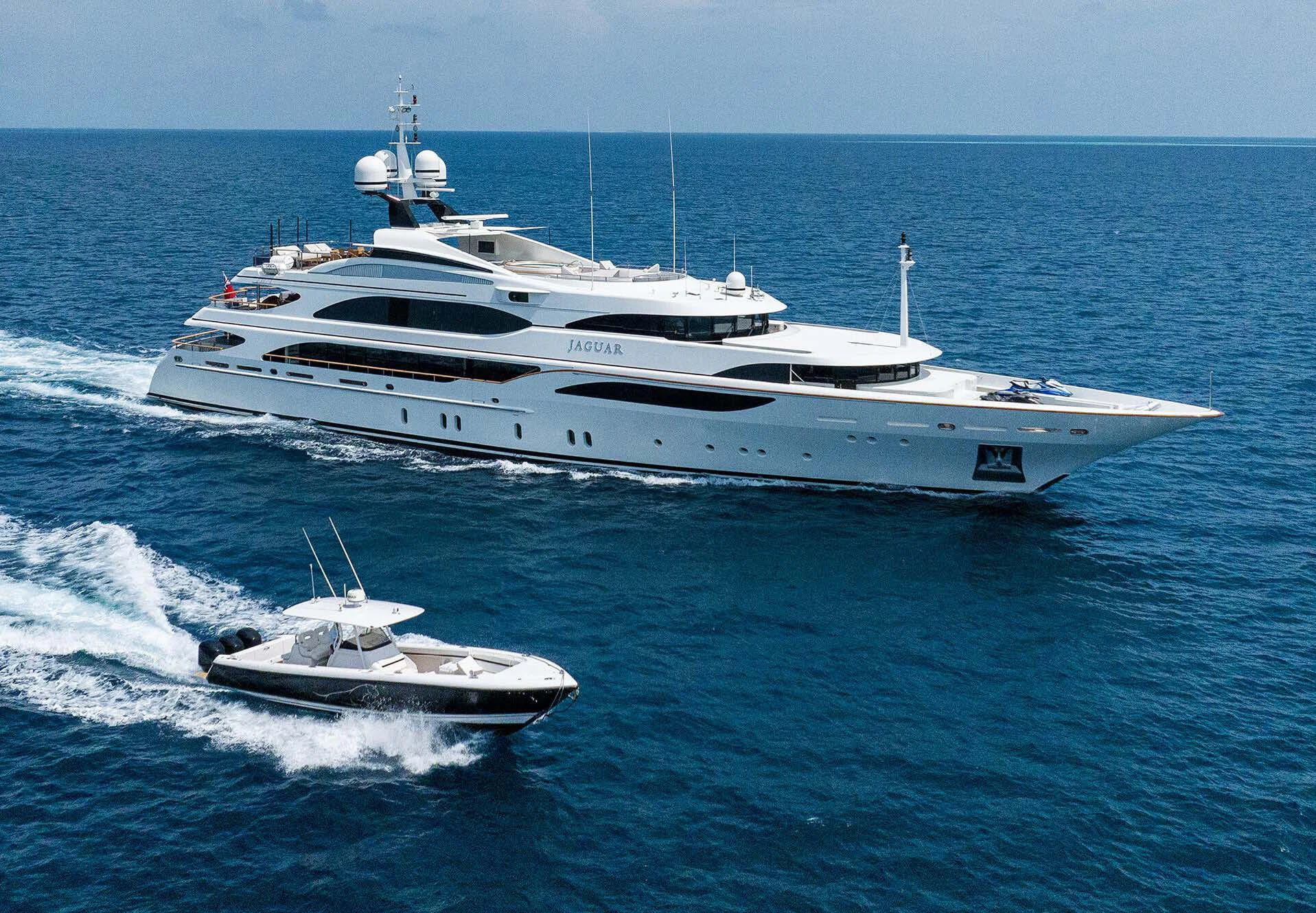 a large white yacht with a smaller boat on it aboard JAGUAR Yacht for Charter