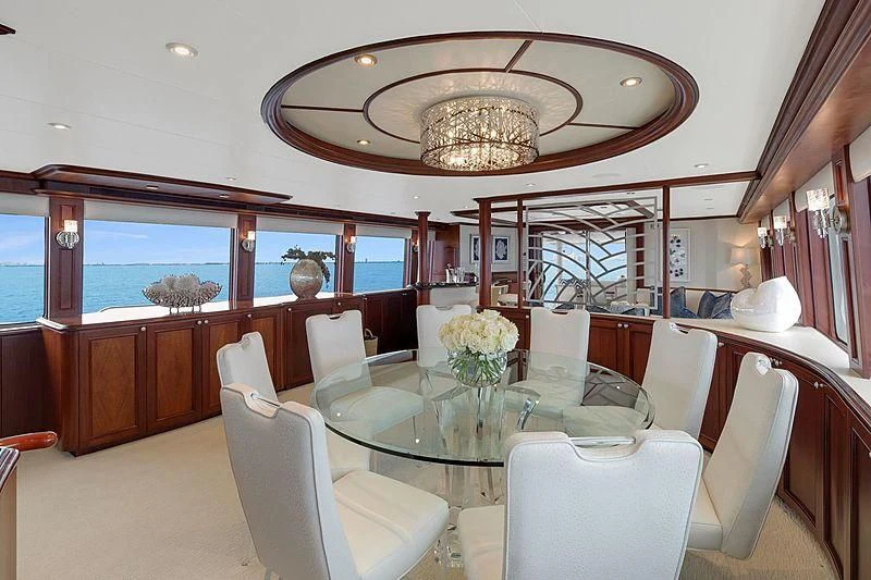 a dining room with a chandelier above the table aboard LEMONADE Yacht for Sale