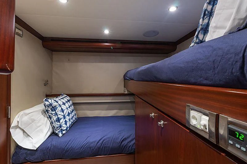 a bedroom with a bed and a dresser aboard LEMONADE Yacht for Sale