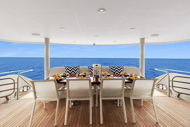 a table set for a meal on a deck overlooking the ocean aboard LEMONADE Yacht for Sale