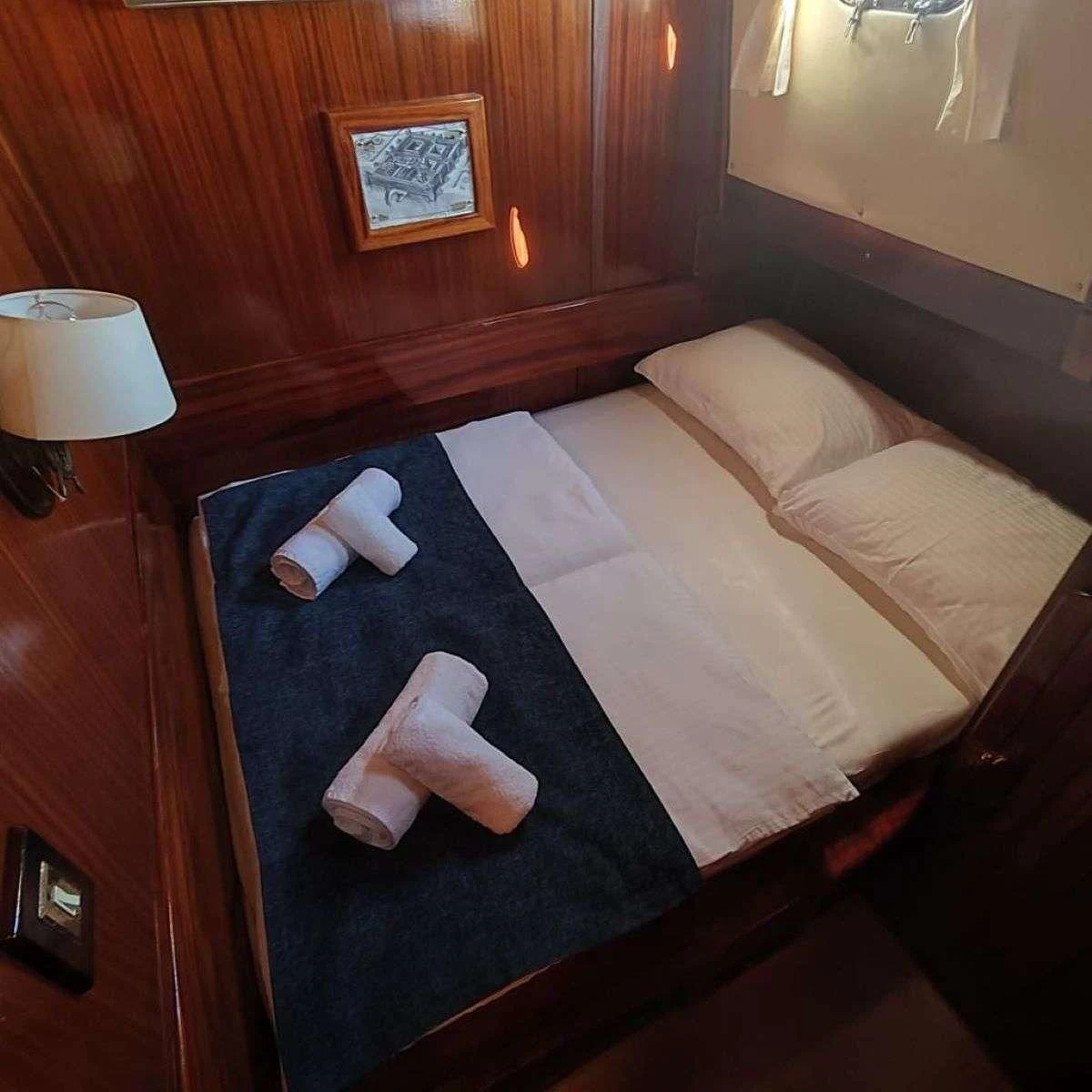 a bed with a white comforter aboard W Yacht for Sale