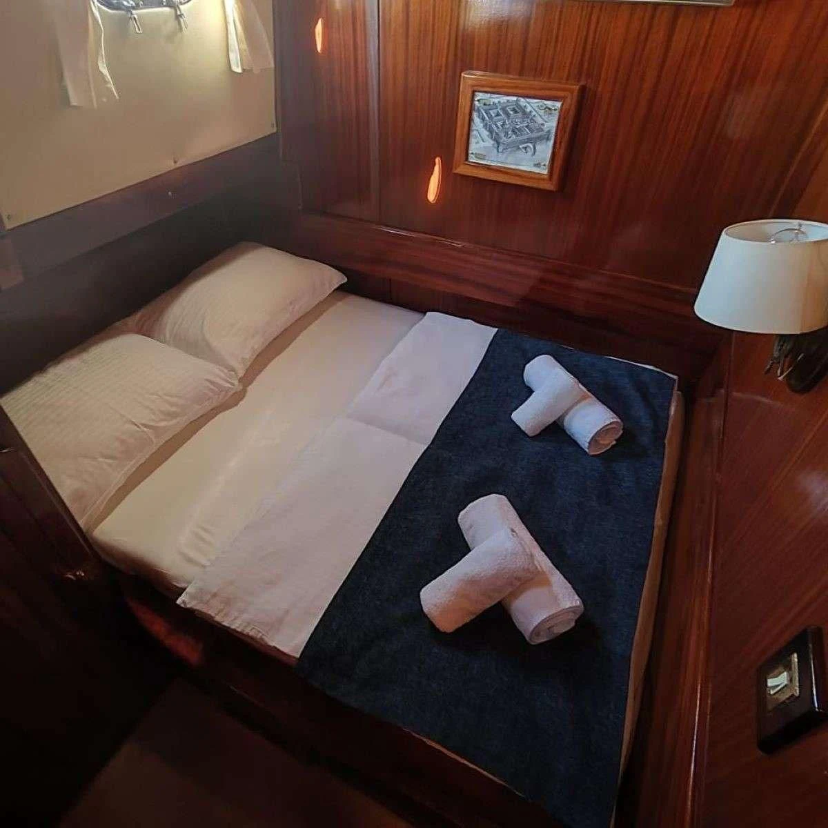 a bed with a white sheet aboard W Yacht for Sale