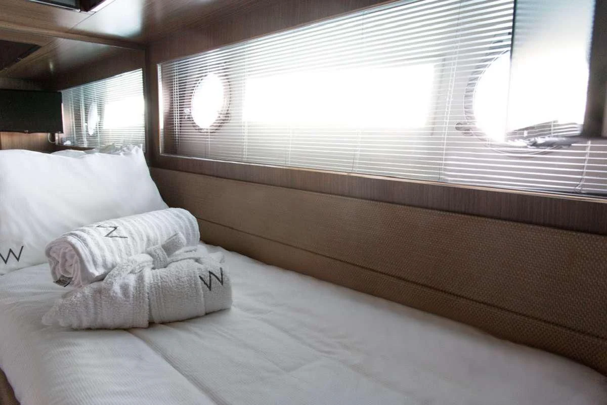 a bed with a white pillow aboard W Yacht for Sale