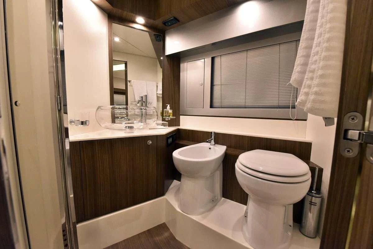 a bathroom with a sink toilet and a mirror aboard W Yacht for Sale