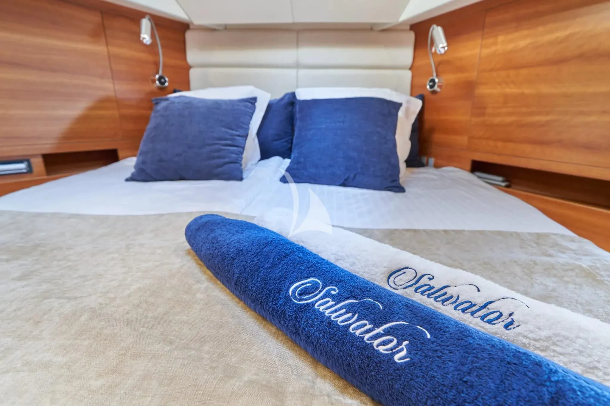 a bed with a blue and white pillow and a blue and white blanket aboard W Yacht for Sale