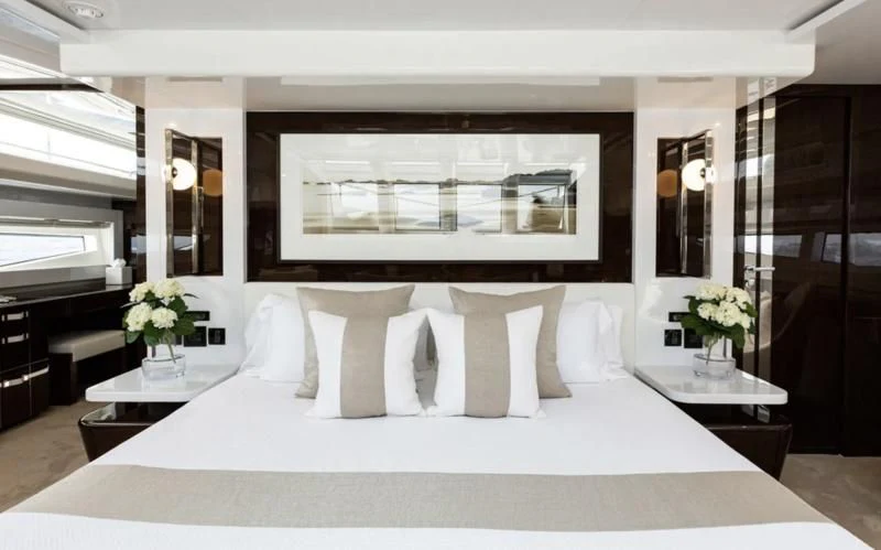 a bed with white sheets and pillows aboard THETIS Yacht for Sale