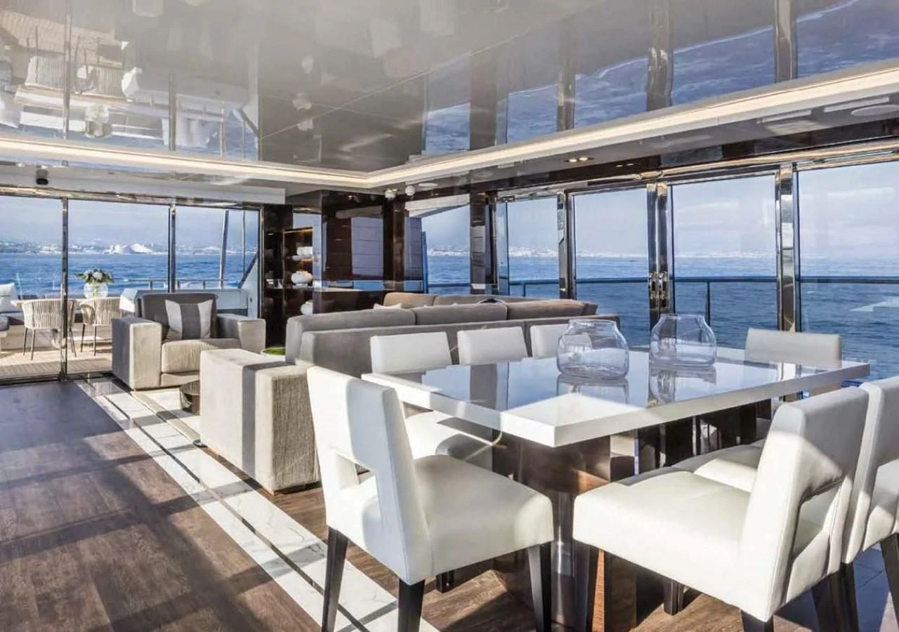 a room with a table chairs and a view of the water aboard THETIS Yacht for Sale