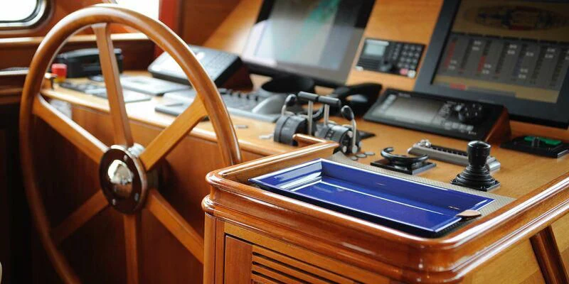 a wooden desk with a computer and other electronic devices on it aboard AVENTURA Yacht for Sale