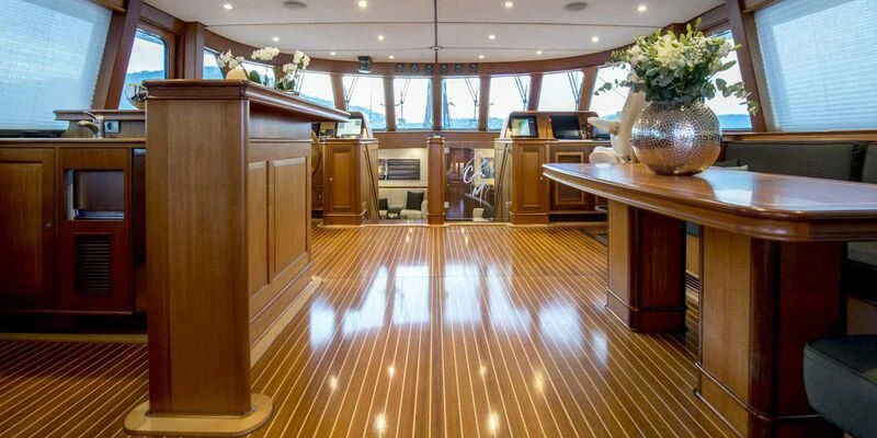 a room with a wood floor and a plant in a pot on the table aboard AVENTURA Yacht for Sale
