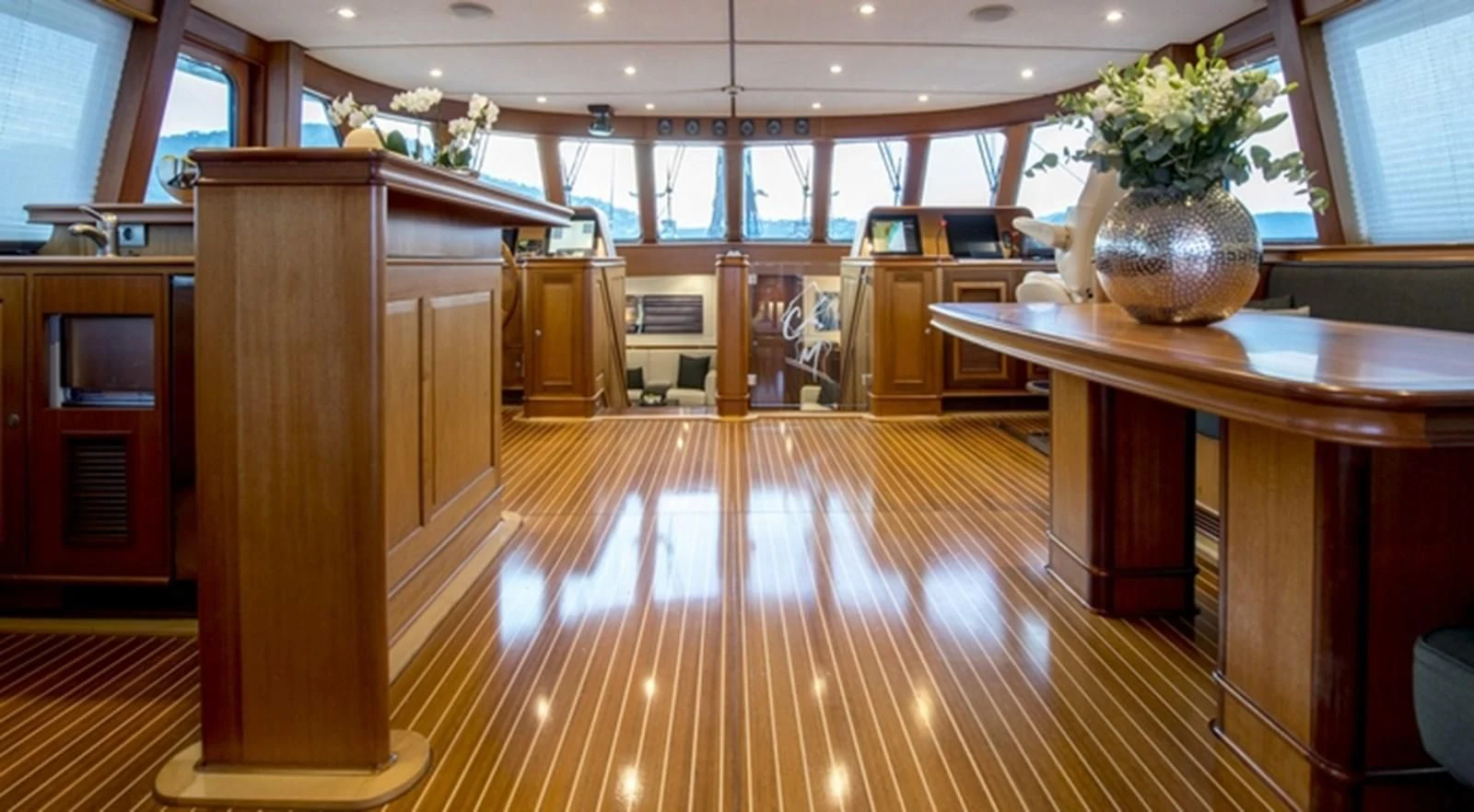 a room with a wood floor and a large vase with a plant in it aboard AVENTURA Yacht for Sale