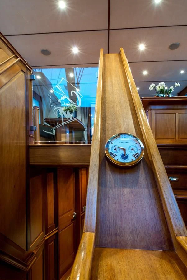 a clock on a wood table aboard AVENTURA Yacht for Sale
