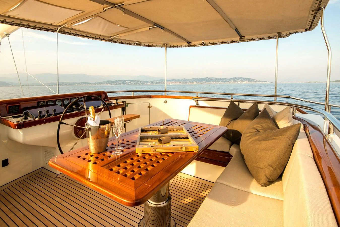 a table with a game controller and a glass of water on a balcony aboard AVENTURA Yacht for Sale