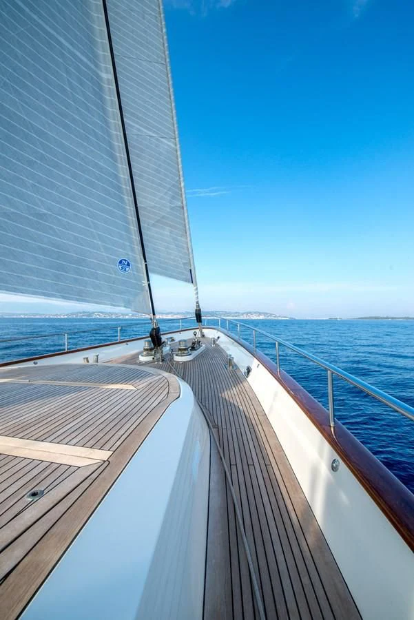 a deck with a railing and a building in the background aboard AVENTURA Yacht for Sale