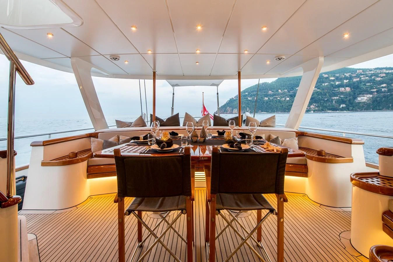 a table with chairs and a view of a city aboard AVENTURA Yacht for Sale