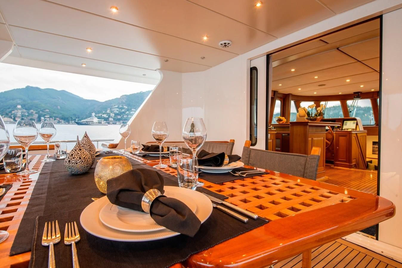 a large fish on a plate with a glass of wine and a large fish on a table with aboard AVENTURA Yacht for Sale