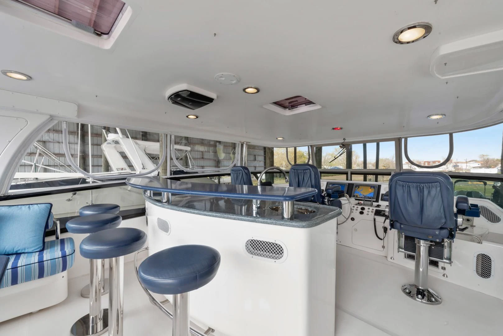 inside of a vehicle with chairs and tables and a blue chair aboard CLEW LESS Yacht for Sale