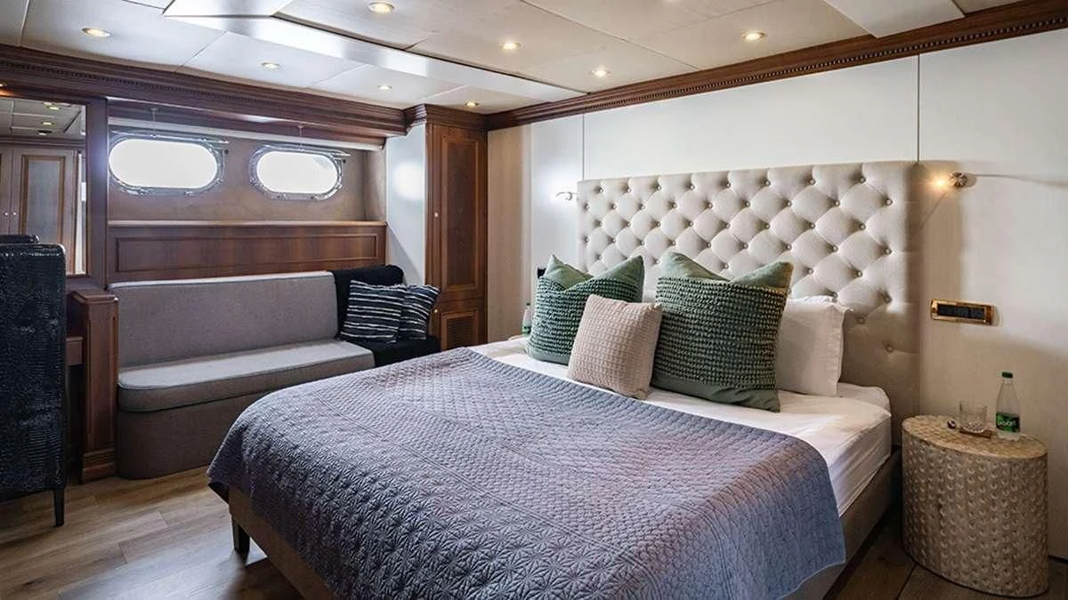 a room with a bed and a chair aboard IRAMA Yacht for Sale