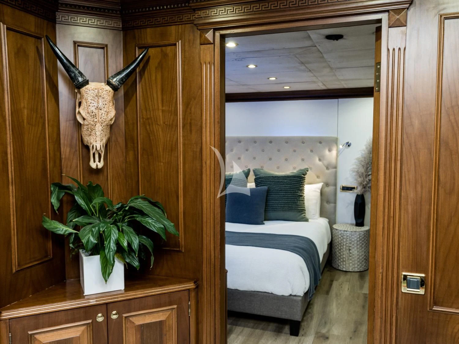 a room with a bed and a plant in it aboard IRAMA Yacht for Sale